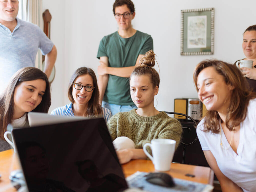 Imagen de personas jovenes en una oficina viendo una computadora 